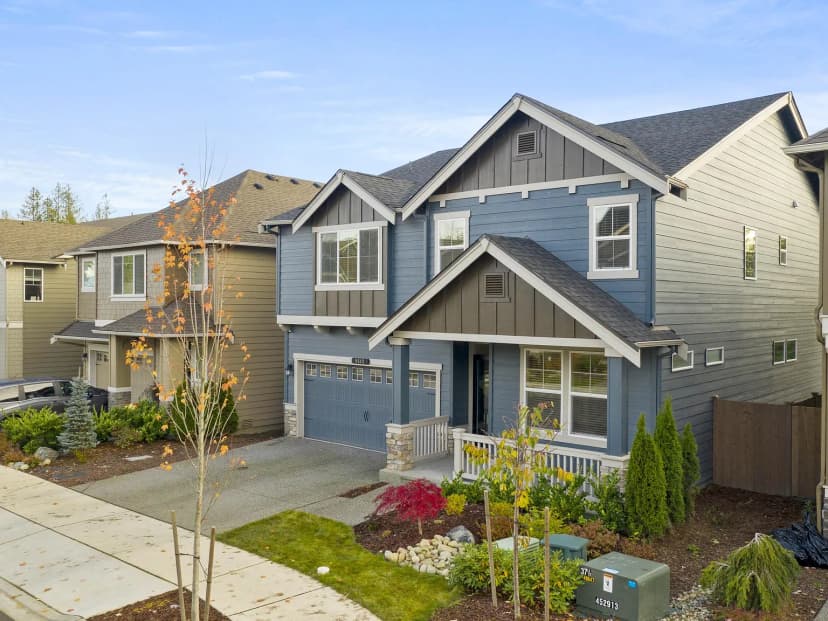 A blue two-storey house with a landscaped front yard
